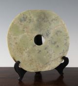A Chinese jade serpentine bi disc, possibly neolithic, 7.75in.; wood stand