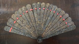 A Chinese tortoiseshell brise fan, late 19th century, the guards and sticks carved in relief with