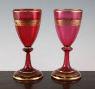 A pair of English cranberry and gilded glass goblets, late 19th century, the bowls and feet