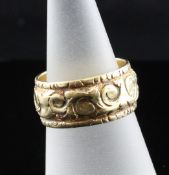 A George IV 18ct gold ring, with continuous carved scroll decoration and later interior