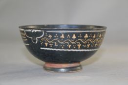 A Greek Gnathian ware black glazed bowl, c.4th century B.C., decorated in coloured slips with