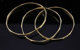A set of three middle eastern gold bangles, with engraved decoration, unmarked, 34.4 grams.