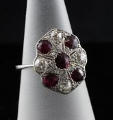 A 1920`s platinum and gold, ruby and diamond cluster dress ring, of shaped oval form, size L.