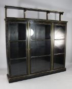 A late Victorian ebonised parcel gilt bookcase, the later raised open superstructure with brass