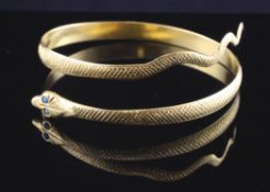 A middle eastern gold and turquoise set serpent bangle, gross 36.6 grams.