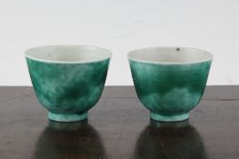 A pair of Chinese green glazed porcelain tea bowls, 18th century, 2.5in. and 2.6in.