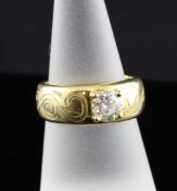 A modern 18ct gold and claw set solitaire diamond ring, with scroll engraved shank, the round