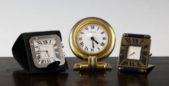 Three modern Cartier travelling timepieces with red suede slip cases, Largest 3.75in.