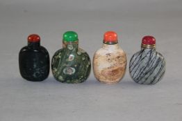Four Chinese jasper snuff bottles, one with fossil inclusions and a green ground, second with