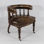 A Victorian carved oak leather upholstered tub shaped desk chair, with fluted front legs and