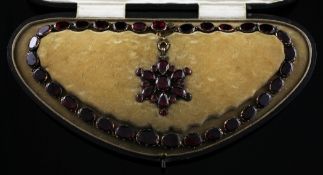 A late Victorian gold and foiled back garnet necklace and matching pendant, (a.f.), in original