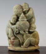 A Chinese green soapstone carving of three Luohan, 20th century, two seated holding a vase, the