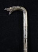 An early 20th century Javanese rhino horn sectional walking cane, the handle carved with the head of