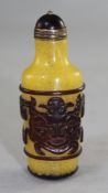 A Chinese red overlaid glass snuff bottle, decorated with archaistic masks and scrolls on a yellow