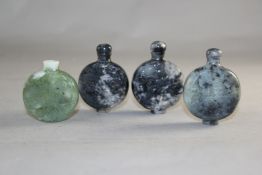 Four Chinese bowenite jade snuff bottles, of drum shape, two carved in relief with phoenixes, one
