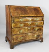 A George I walnut and feather banded bureau, with fall enclosing a stepped interior with pigeon