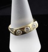 An 18ct gold and three stone gypsy set diamond ring, total diamond weight approximately 0.75ct, size