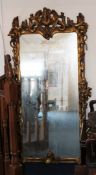 An 18th century and later Continental giltwood wall mirror, carved with dragons and scrolls, 3ft