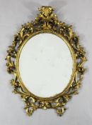 A 19th century Florentine carved giltwood and gesso oval mirror, with bevelled plate, 3ft x 2ft