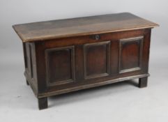 An early 18th century oak coffer, with triple moulded panelled front, raised on peg feet, 4ft 7.