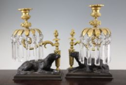 A pair of late 19th century bronze, gilt bronze and cut glass candle holders, the bases formed as