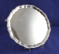 A George V silver salver, of shaped circular form, with gadrooned border, on hoof feet, Edward