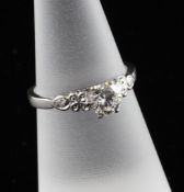 An 18ct white gold solitaire diamond ring, with diamond set foliate shoulders, approximate weight,