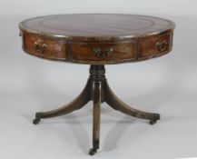 A Regency mahogany drum top library table, with tooled red leather inset top above four real and