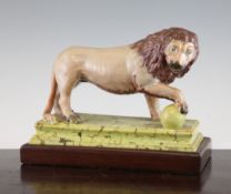 A Staffordshire pearlware figure of a Medici lion, c.1810, his front right paw resting upon a