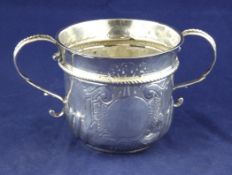 A Queen Anne Britannia standard silver porringer, by Seth Lofthouse, with demi wrythen fluted