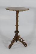 A Victorian carved walnut occasional table, with serpentine top on a faux branch column and tripod