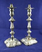 A pair of Edwardian silver candlesticks, now converted to lamps, with waisted knop stems on shaped