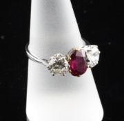 An 18ct gold and platinum three stone ruby and diamond ring, the pierced setting with central oval