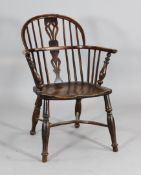 An early 19th century yew and ash Windsor chair, with saddle seat, on turned legs with crinoline