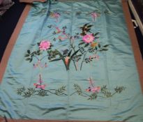 A Chinese embroidered silk panel, decorated with two birds in flight amid flowers on a turquoise