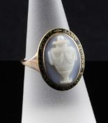 A George III gold, enamel and hardstone cameo memorial ring, with carved cameo of an urn within a