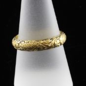 An early 18th century gold memorial band, with chased floral decoration and traces of black