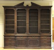 A George III mahogany breakfront library bookcase, c.1770, the broken pediment with dentil cornice