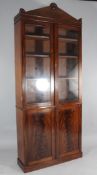 A William IV mahogany bookcase, with two glazed doors above two panelled doors, on plinth base,