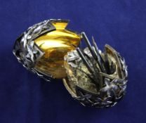 A cased 1970`s parcel gilt silver surprise egg, by Stuart Devlin, decorated with applied flowers and