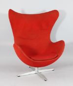 After Arne Jacobsen. An `egg` chair, with red upholstery, on swivel base