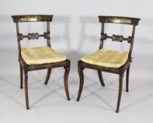 A set of six Regency brass inlaid and carved rosewood dining chairs, with `C` scroll bar backs and