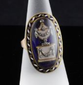 A George III enamelled gold memorial ring, decorated with a diamond set white enamelled urn within a