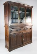 An early 19th century oak housekeeper`s cabinet, with three glazed doors above three short drawers