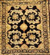 A modern Heriz rug, with four geometric foliate motifs, on a navy blue ground with three row border,