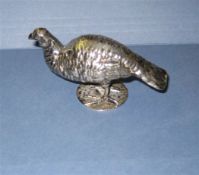 An early 20th century Hanau silver model of a standing pheasant, with textured feathers, on circular