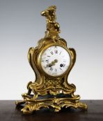 A late 19th century French ormolu mantel clock, surmounted with a bacchic putto over an enamelled