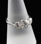 An 18ct white gold three stone diamond ring, the central brilliant cut stone approximately 1.57ct