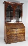 A George I design walnut bureau bookcase, with two arched glazed door over fall enclosing a fitted