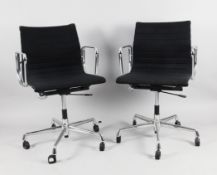 A pair of Charles and Ray Eames office chairs from the Aluminium Group series with chromed aluminium